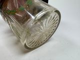 a glass jar with a flower inside of it on a table