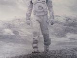 poster of a man in a space suit standing in front of a snow covered mountain