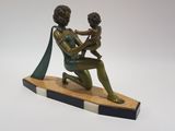 statue en bronze représentant une femme tenant un enfant sur une planche de surf