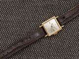 un gros plan d'une montre montée sur un bracelet en cuir marron