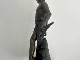 bronze statue of a man with a gun on a black base