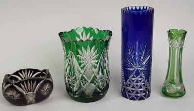 plusieurs vases en verre de différentes couleurs sont alignés sur une surface blanche