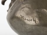 a bronze vase that has a bird on it ' s head