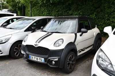 trois petites voitures garées en rangée sur un parking