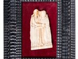 carved ivory figurine of a man and a woman in a frame