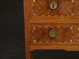 a wooden chest of drawers with a marble top