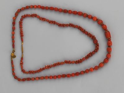 a close up of a red beaded necklace with a gold clasp
