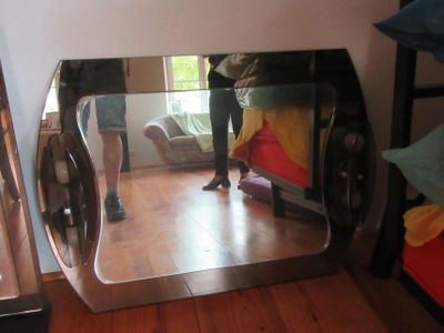 une personne debout devant un miroir dans une pièce