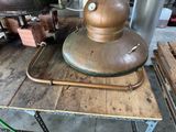 a large copper pot sitting on top of a wooden table
