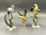 trois figurines d'oiseaux perchés sur une branche