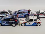 several toy cars are lined up in a row on a white surface