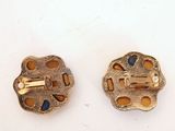 two pieces of gold colored metal with holes and holes on them