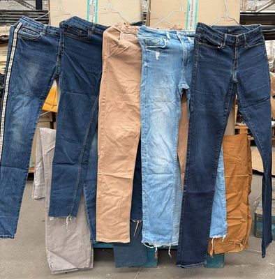 plusieurs paires de jeans suspendues à un portant dans un entrepôt