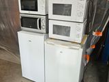 several microwaves and refrigerators stacked on top of each other in a room