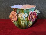 un vase vert orné de fleurs, posé sur une table rouge