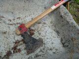 an old axe sitting in a cement bowl on the ground