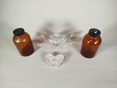 trois bouteilles et un saladier en verre posés sur une table