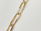 a close up of a gold chain bracelet on a white surface