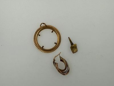 two gold rings and a pair of earrings on a table