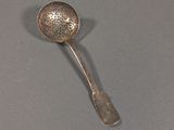 silver plated spoon with a flower design on it on a gray surface