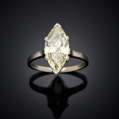 a yellow and white diamond ring on a black surface
