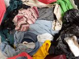 a pile of clothes in a suitcase on the floor