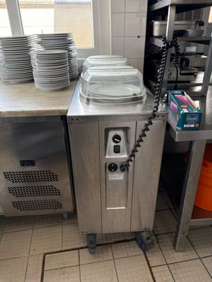 Plusieurs assiettes sont empilées sur un plan de travail dans la cuisine d'un restaurant.