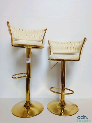 pair of gold metal bar stools with white upholstered seats