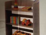 a book shelf with a toy bus and books on it