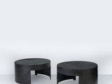 deux tables noires posées sur un sol blanc