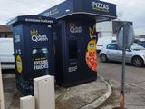 a vending kiosk on the corner of a parking lot