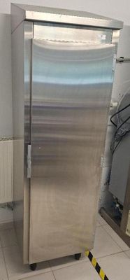 a stainless steel refrigerator in the corner of a room