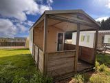 une petite cabane en bois nichée au milieu d'un champ verdoyant