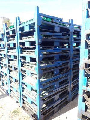 many pallets stacked on top of each other in the dirt