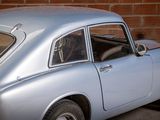 a silver car parked in front of a brick wall