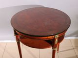 a small round table with a wooden top on a tiled floor