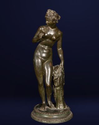 une statue en bronze représentant une femme tenant un sac