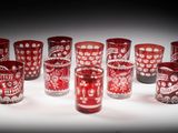 Plusieurs verres rouges sont alignés sur une surface blanche