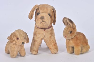 trois peluches assises les unes à côté des autres sur une surface blanche
