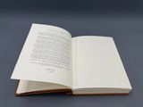 an open book sitting on top of a table next to a gray background