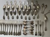 a lot of spoons and forks laid out on the table