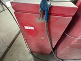 a red refrigerator with a blue hose attached to it