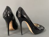 black high heeled shoes with a gold buckle on the toe