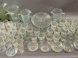 a lot of glasses and vases sitting on a table