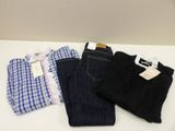 trois paires de jeans et une chemise posées sur une table