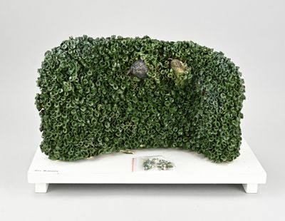 a sculpture of a green plant on a white stand