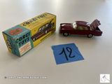 une petite voiture miniature portant un numéro, à côté d'une boîte