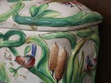 a large vase with a bird on it sitting on a table