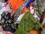 a suitcase full of clothes and clothes sitting on the floor