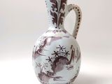 un vase blanc et marron posé sur une surface blanche